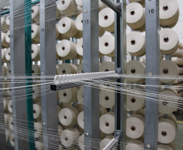 Each warp is threaded through a heddle which sits inside shafts that can be lifted up or down.