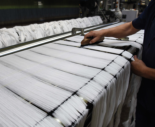 The warp beam is mounted onto the back of the loom.